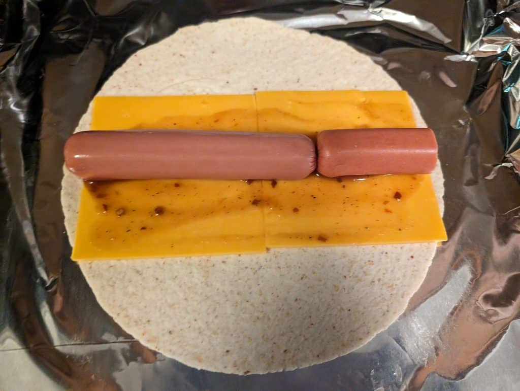 Low carb wrap with cheddar cheese and BBQ sauce and hot dog