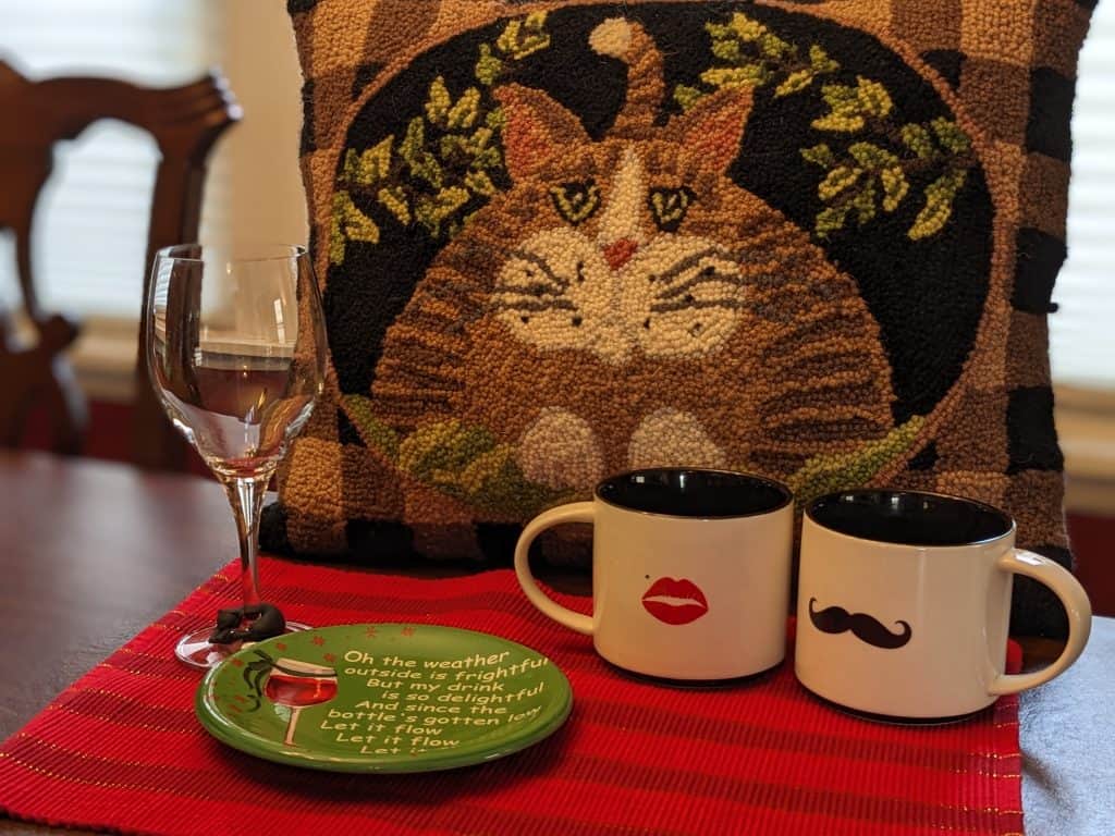Decorative cat pillow, wine glass, appetizer plate, two coffee mugs