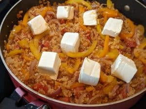 Incorporating the cream cheese into the cooked veggies