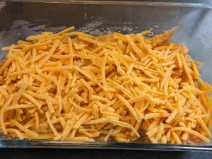 All ingredients in casserole dish topped with shredded cheddar