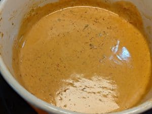 Heavy cream and chipotle peppers thickened in saucepan