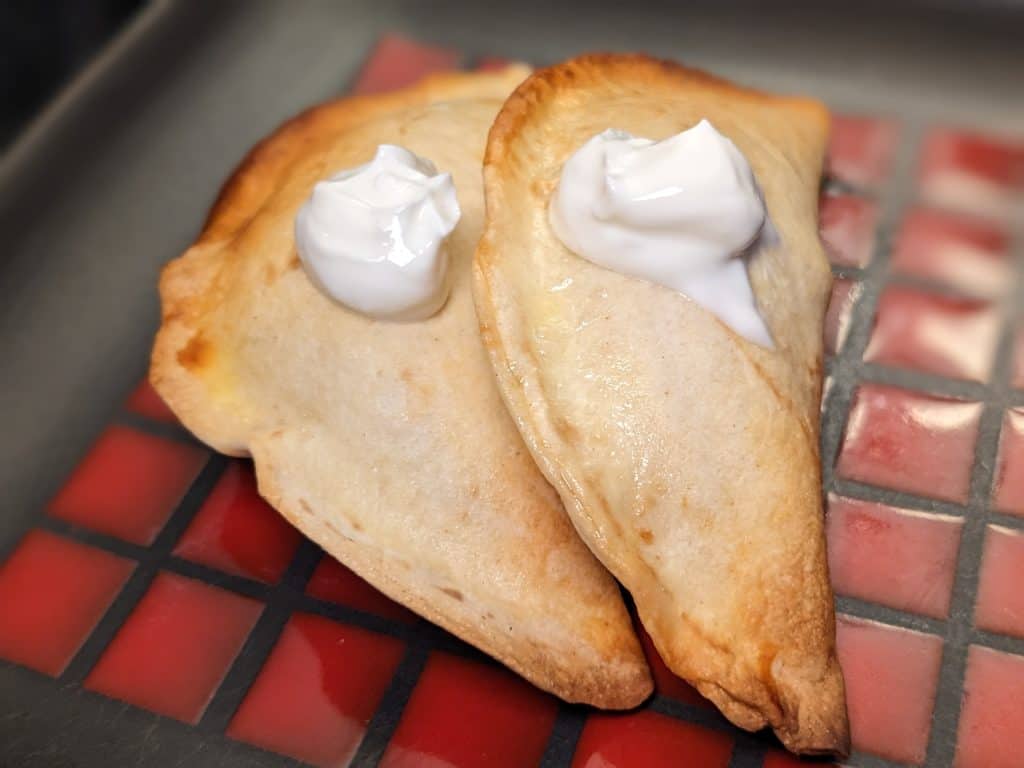 Two Turkey Empanadas finished with sour cream