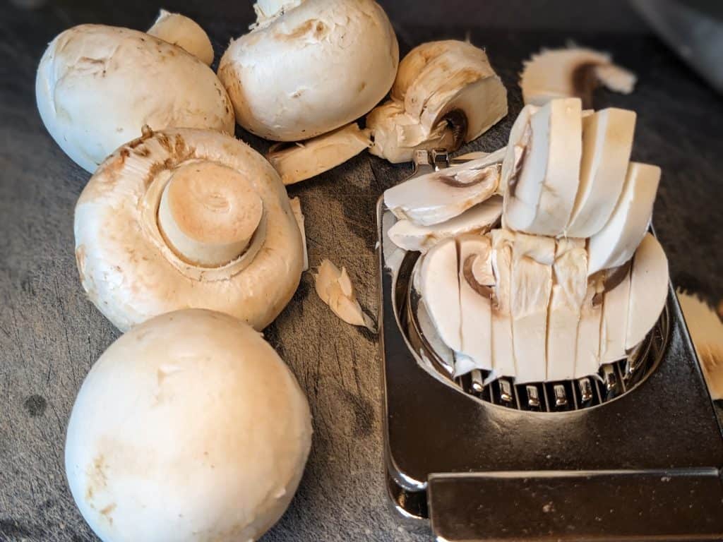 Raw mushrooms being sliced