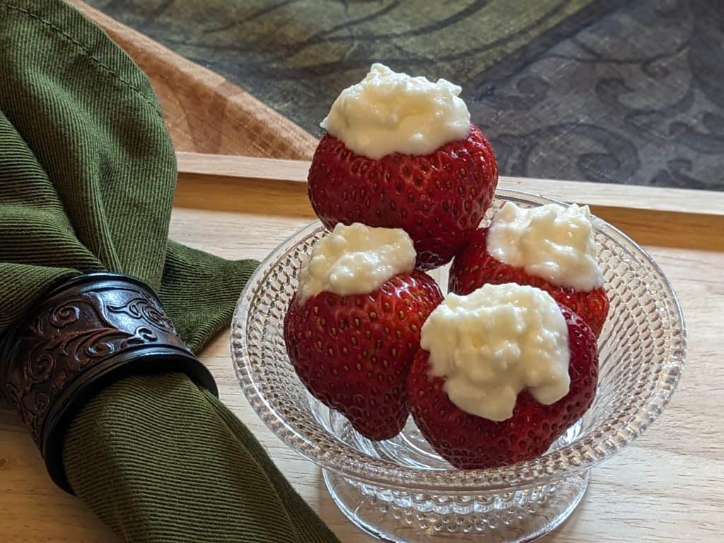 Four Buttercream Stuffed Strawberries in a glass bowl