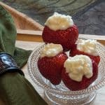 Four Buttercream Stuffed Strawberries in a glass bowl