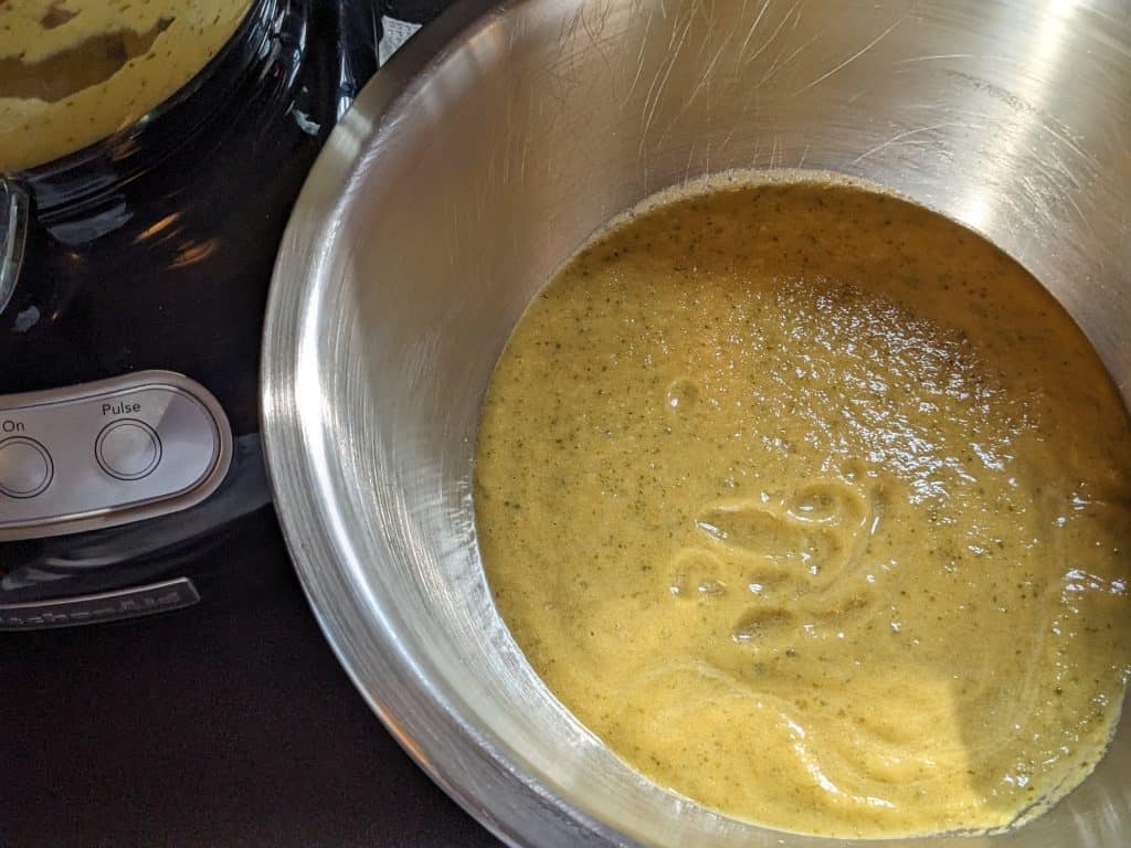 Combining batches of blended zucchini cubanelle soup in a large mixing bowl