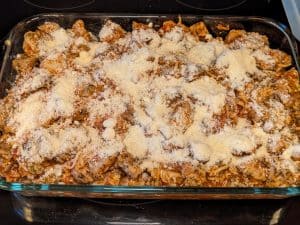 Chicken Parmesan Casserole topped with cheese but not yet baked