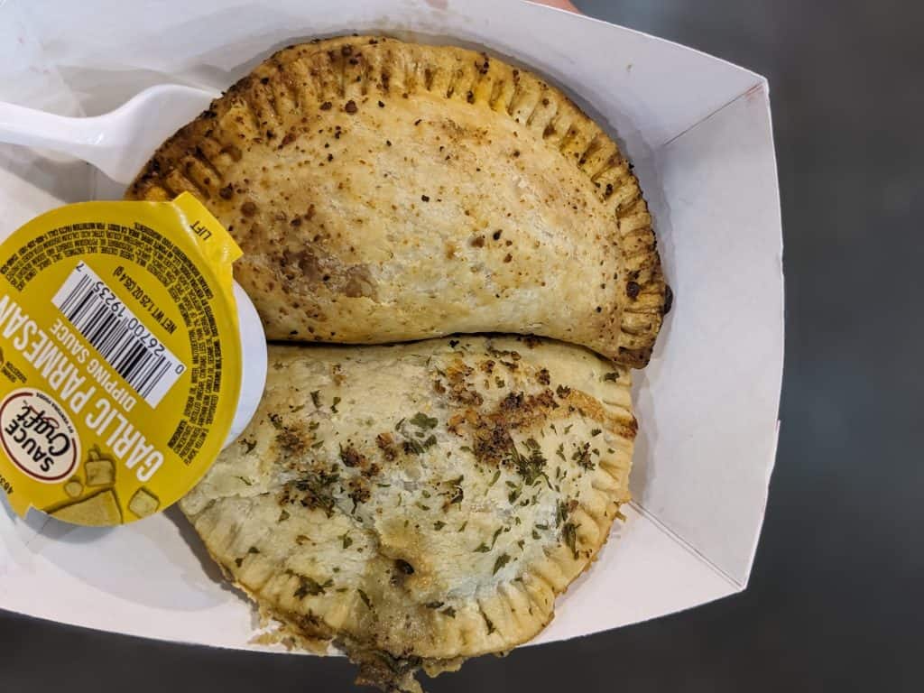 Italian Dipper Hand Pies in a paper basket with garlic parmesan dipping sauce