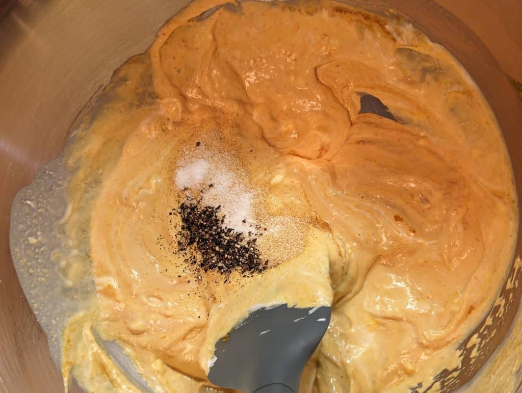 Creamy pumpkin sauce for Broccoli Pumpkin Queso Casserole being mixed with spices