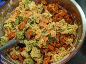 Combining all ingredients in mixing bowl for Broccoli Pumpkin Queso Casserole