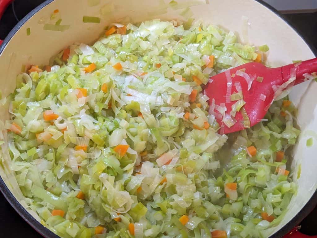 Softened leeks, onions, carrots, and celery in a Dutch oven