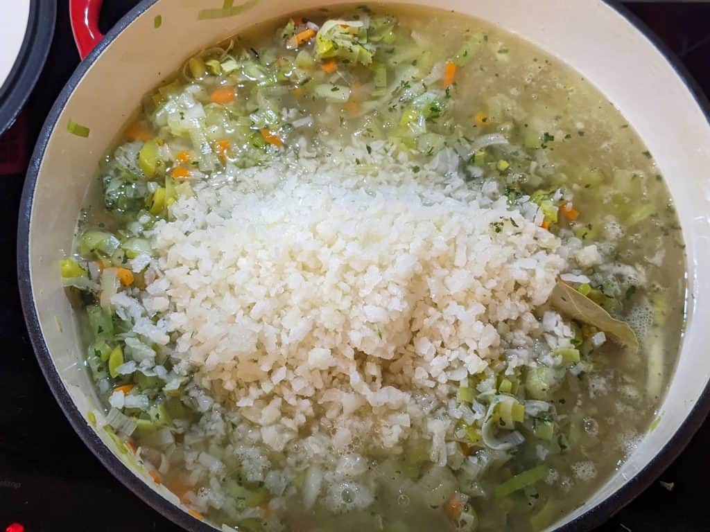 Softened leeks, onions, carrots, and celery in Dutch oven with addition of cauliflower rice and chicken broth