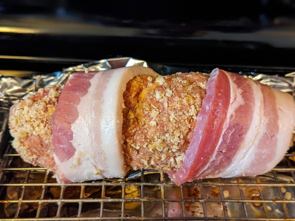 Wrapping raw bacon around personal-sized meatloaf