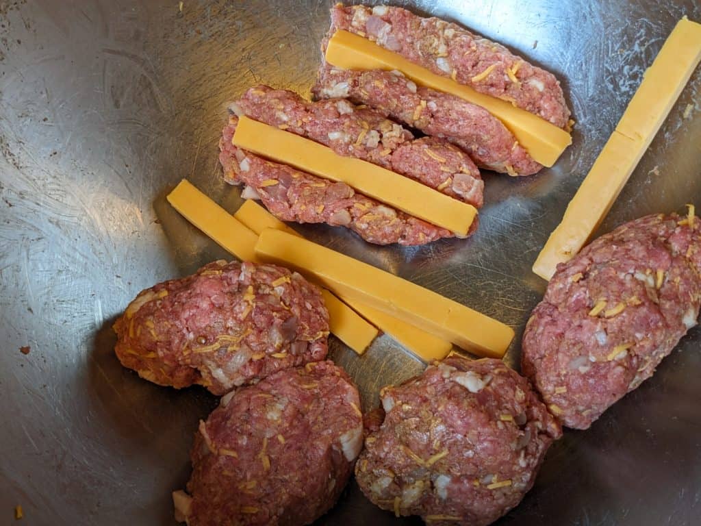 Wrapping meatloaf meat around cheddar cheese sticks