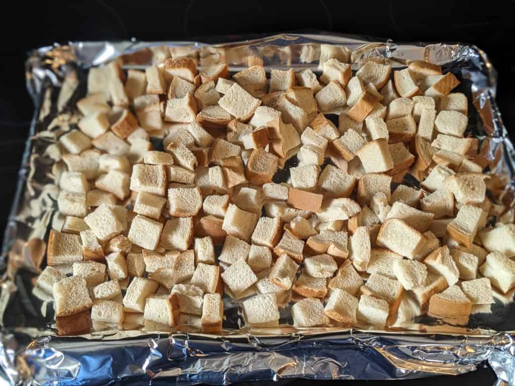 Dried keto bread cubes on a rimmed baking sheet