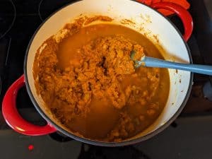 Adding pumpkin purée and broth to Savory Pumpkin Soup