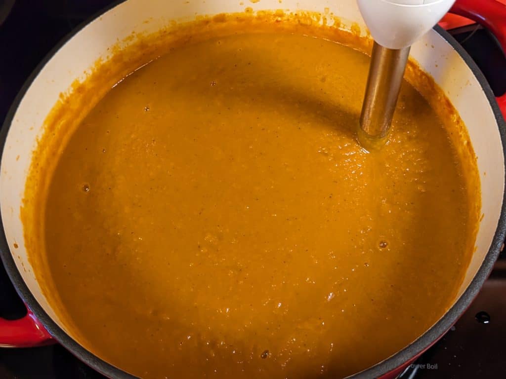 Immersion blender in Dutch oven of Savory Pumpkin Soup