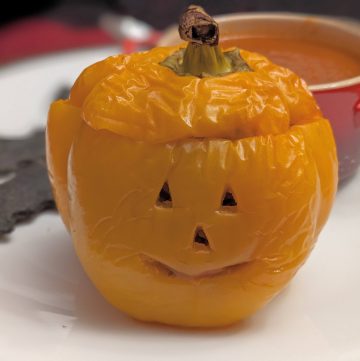 Stuffed Orange Bell Pepper carved to look like a Jack-O-Lantern
