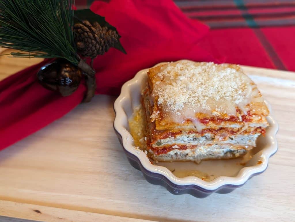 Side view of a slice of Easy Low Carb Lasagna in a ceramic dish