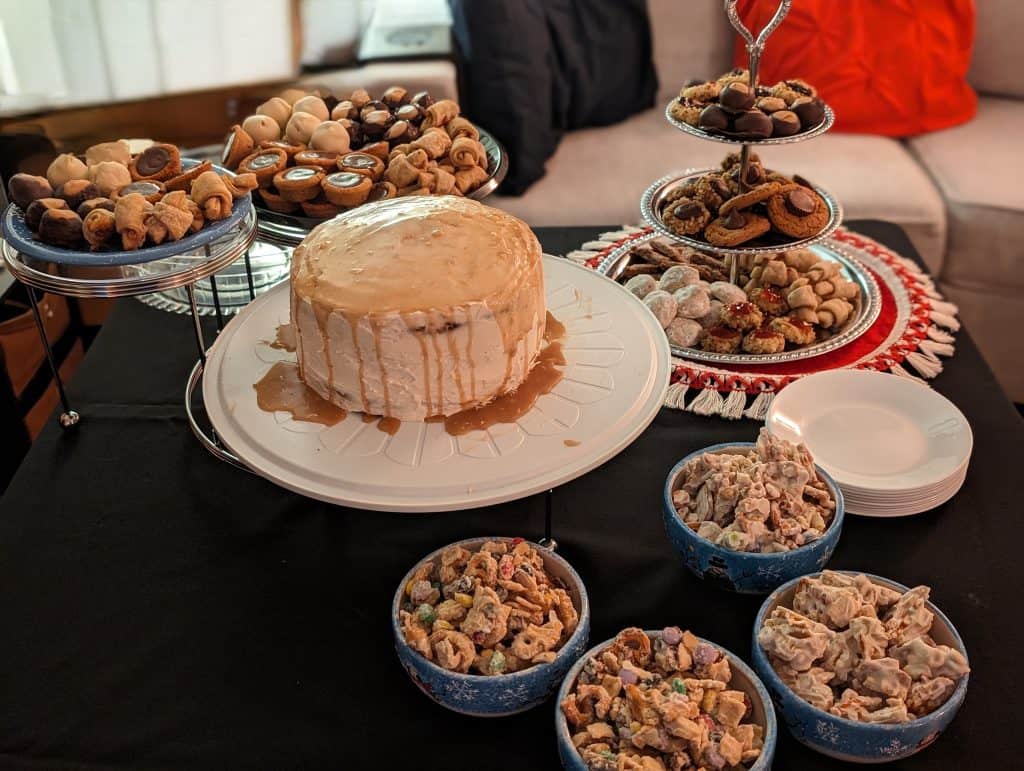 Holiday Party Dessert Table Containing: Keto Meow Munch, Moose Munch, Pumpkin Layer Cake with Caramel Buttercream Frosting, Keto Buckeyes, Keto Butterball Cookie Pops, Keto Peanut Butter Cookie Cups, Keto Butter Horns, Butterballs, Jelly Thumbprints, Butter Horns, Chocolate Cinnamon Log Cookies, Chocolate Thumbprints, Peanut Butter Blossoms, and Buckeyes