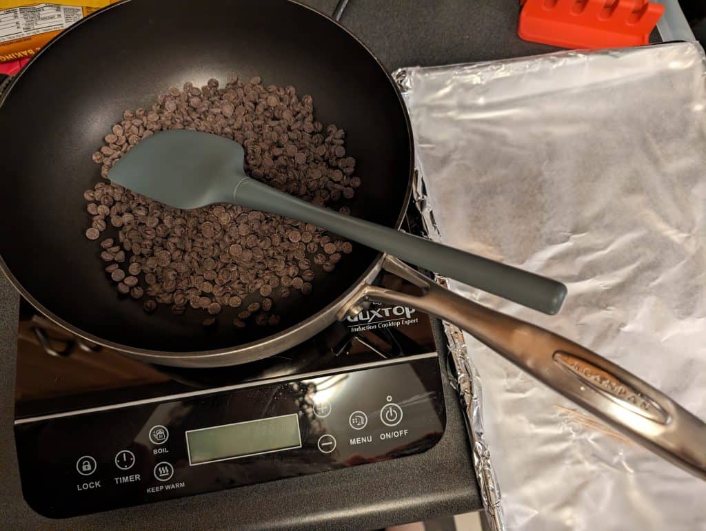 Sugar free chocolate chips in a saucepan on an induction burner ready to be melted