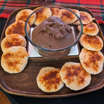 A tray containing Sugar Free Chocolate Hazelnut Hummus in the center surrounded by BBQ Dusted Keto Flatbread Pieces