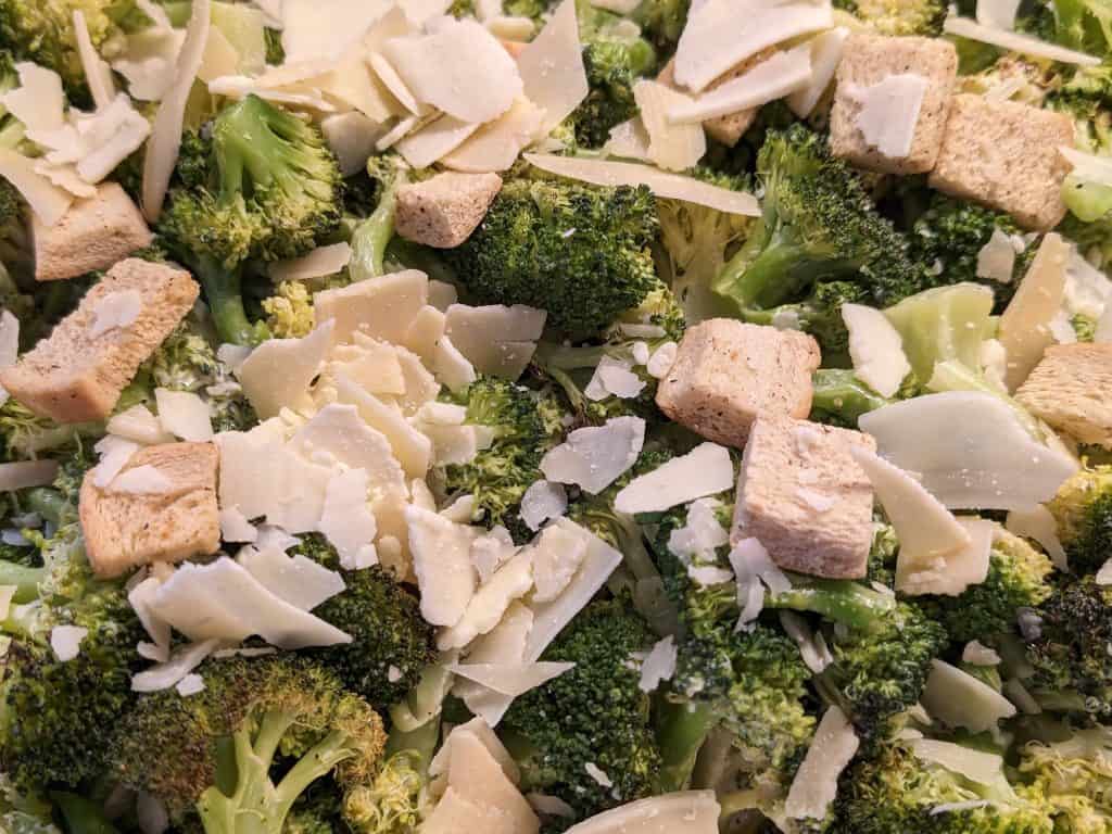 Broccoli Caesar Salad with keto croutons and shaved Parmesan in a pan