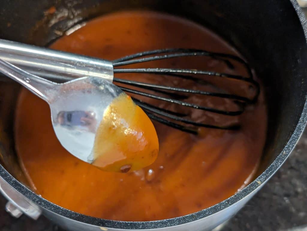 Cooked base for Chipotle Keto Ice Cream showing liquid coating back of spoon