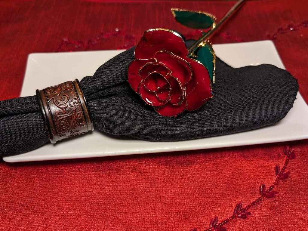 Fancy Entrees Feature image - glass rose and black cloth napkin on white plate