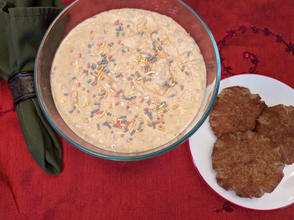 Keto Cake Batter Dip in a serving bowl next to a plate of Keto Snickerdoodle Cookies