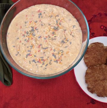 Keto Cake Batter Dip in a serving bowl next to a plate of Keto Snickerdoodle Cookies