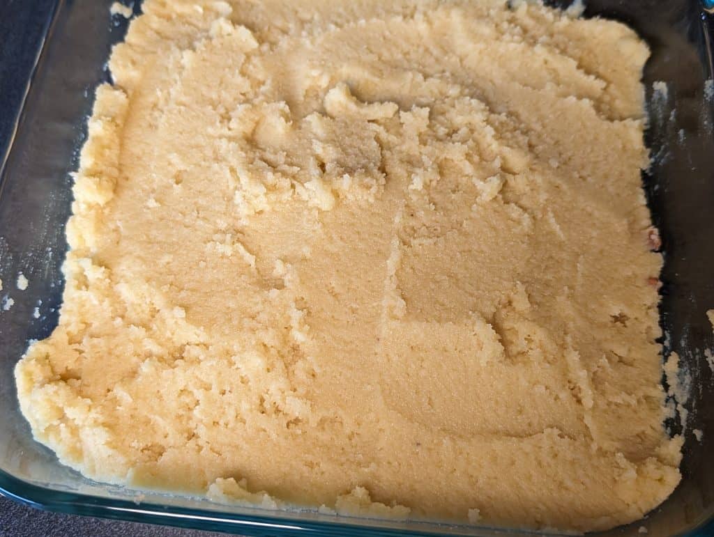Keto Yellow Cake batter on top of chopped pecans in pan