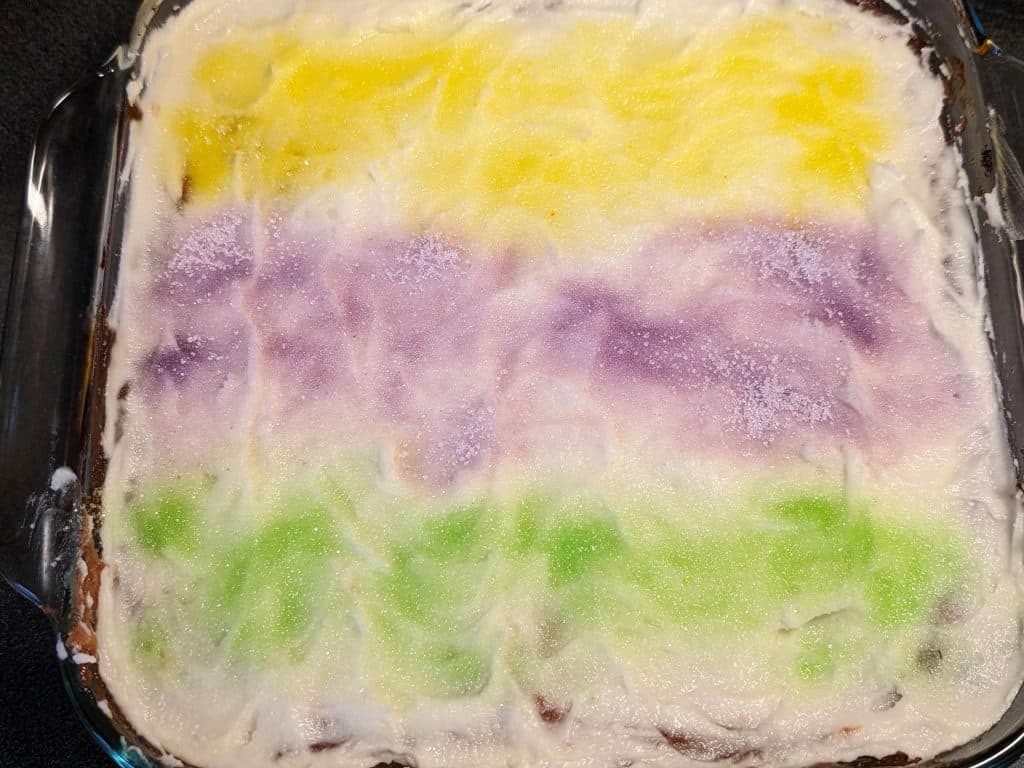 King Cake Earthquake Cake frosted and decorated with colored erythritol