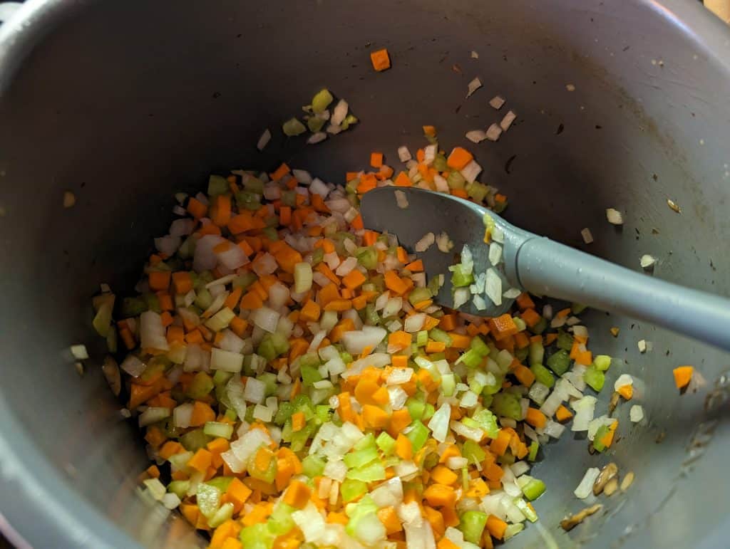 Sautéing chopped celery, onions, and carrots in an Instant Pot