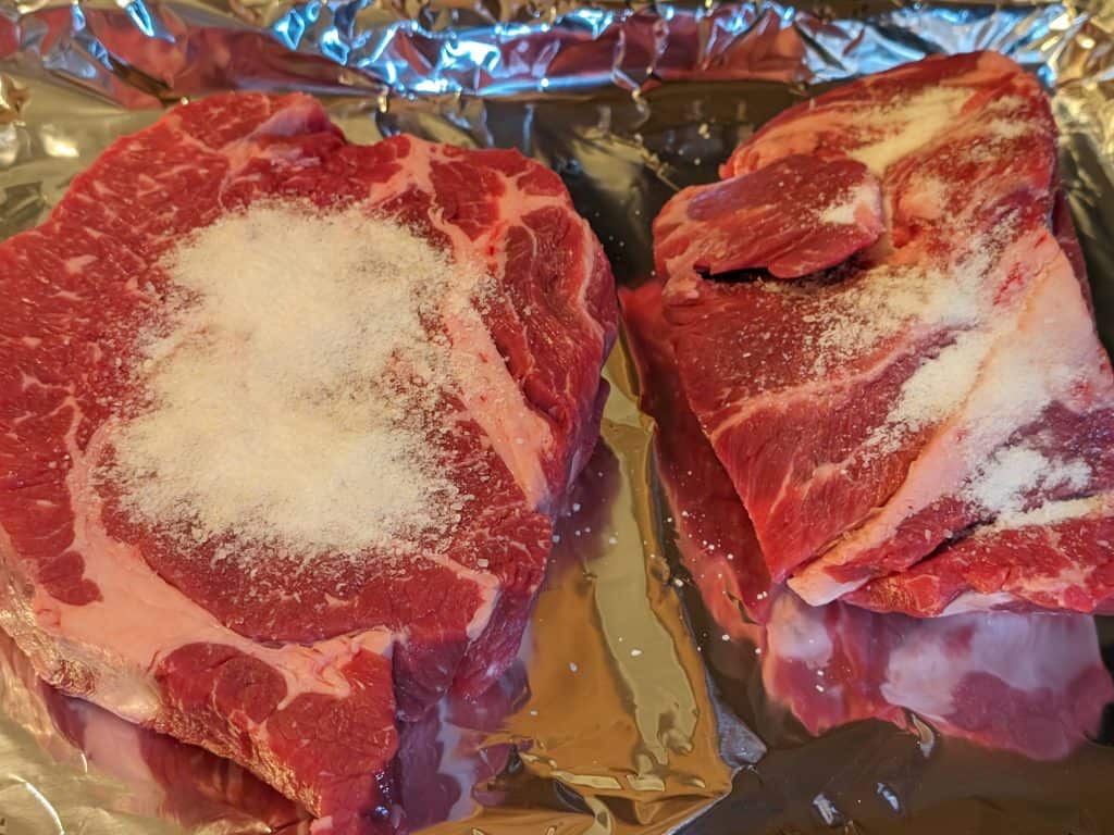 2 beef chuck roasts ready to be rubbed with kosher salt