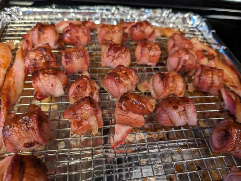 Bacon-Wrapped Low Carb BBQ Hot Dog Bites on a wire rack in a baking sheet lined with aluminum foil