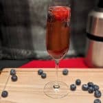 Berry Sparkling Wine Cocktail garnished with blueberries and strawberries