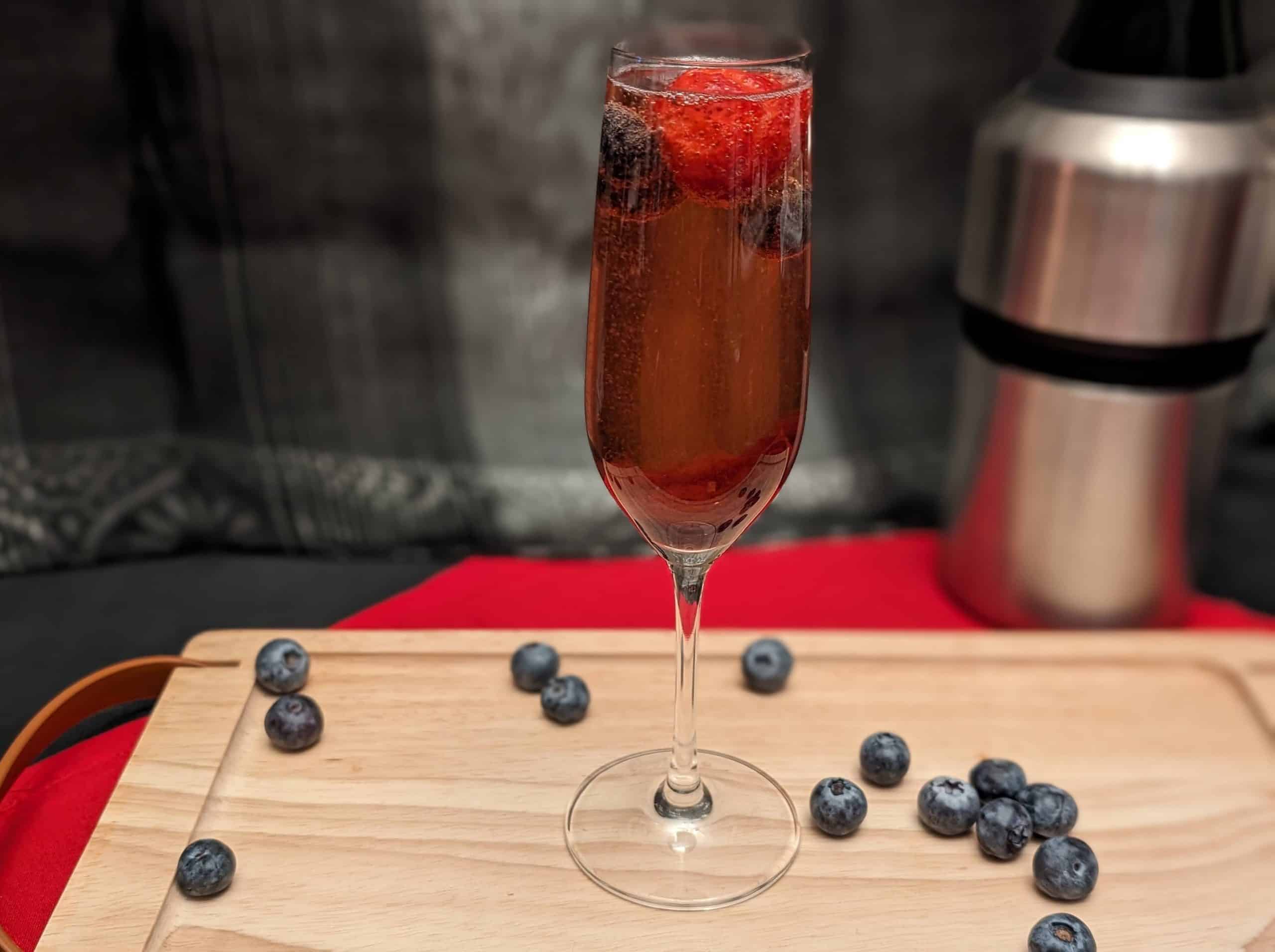 Berry Sparkling Wine Cocktail garnished with blueberries and strawberries