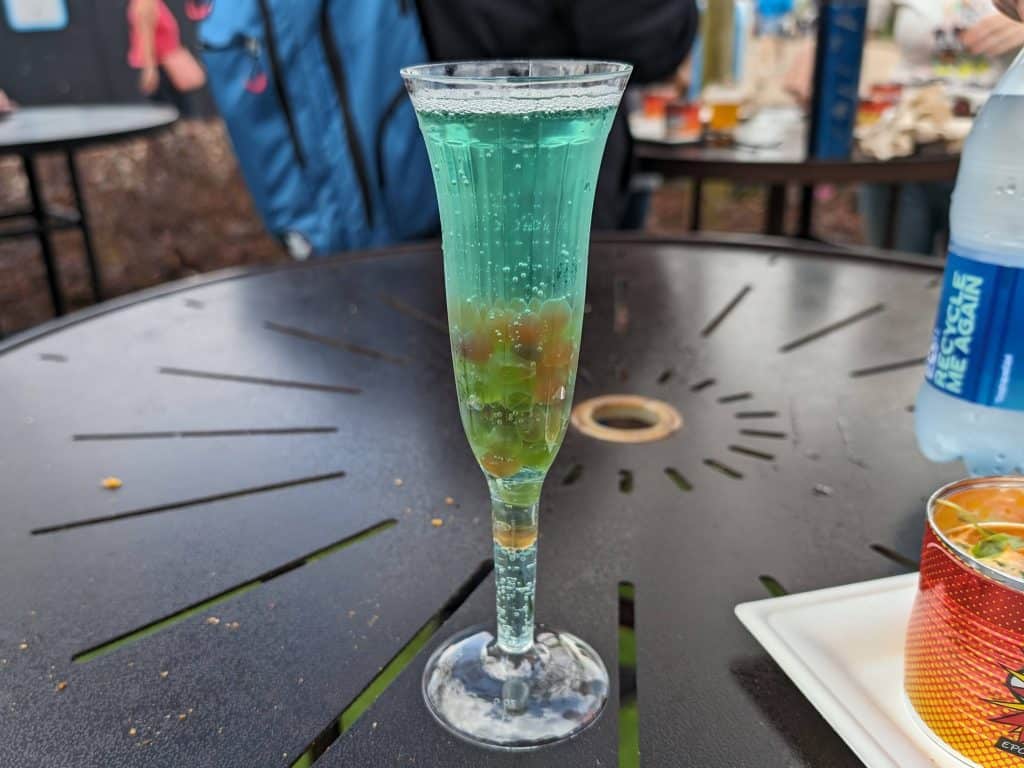 Blanc de Bleu Cuvee Mousseux cocktail from Epcot - blue sparkling wine with boba pearls in a plastic champagne flute