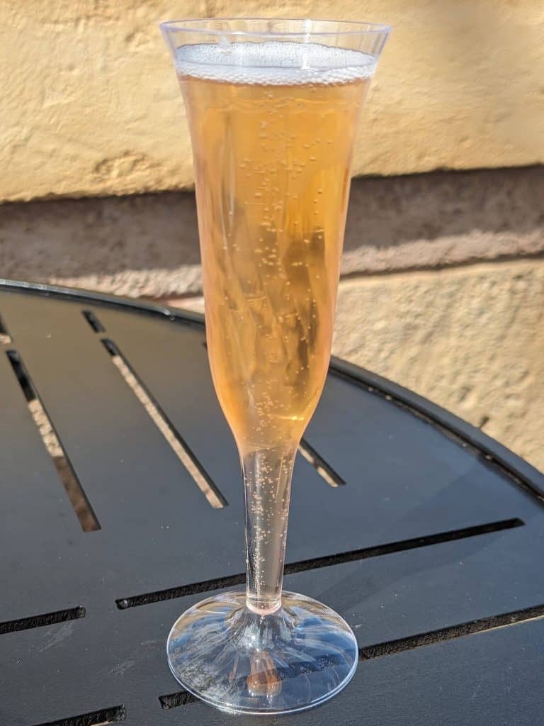 A brut rose in a plastic champagne flute on a table