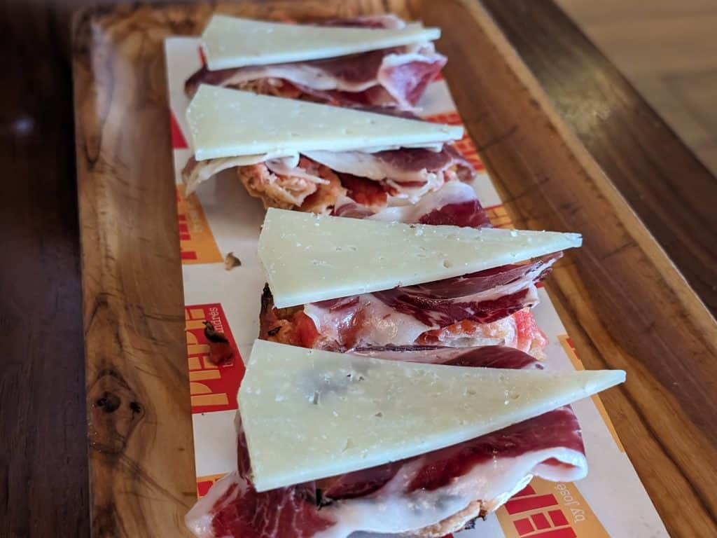 Crispy bread slices topped with a slice of Iberico Ham and a slice of Manchego cheese