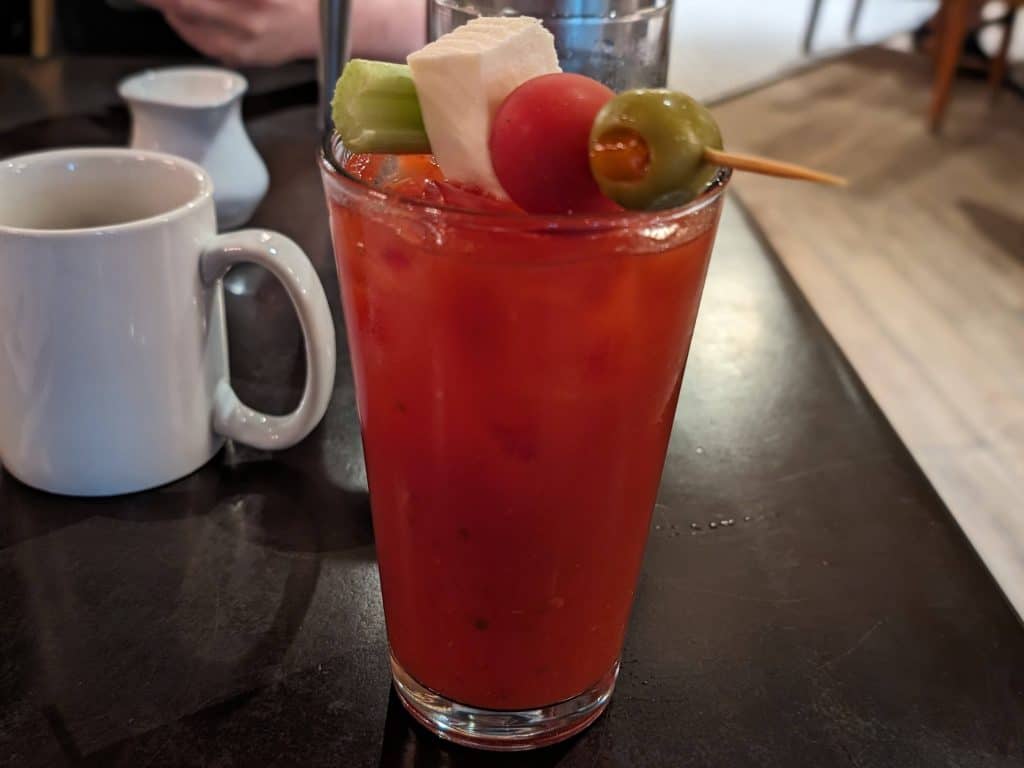 Caprese Bloody Mary garnished with celery, fresh mozzarella, cherry tomato, and green olive