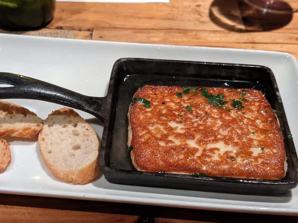 Fried Saganaki cheese on a plate with toast slices