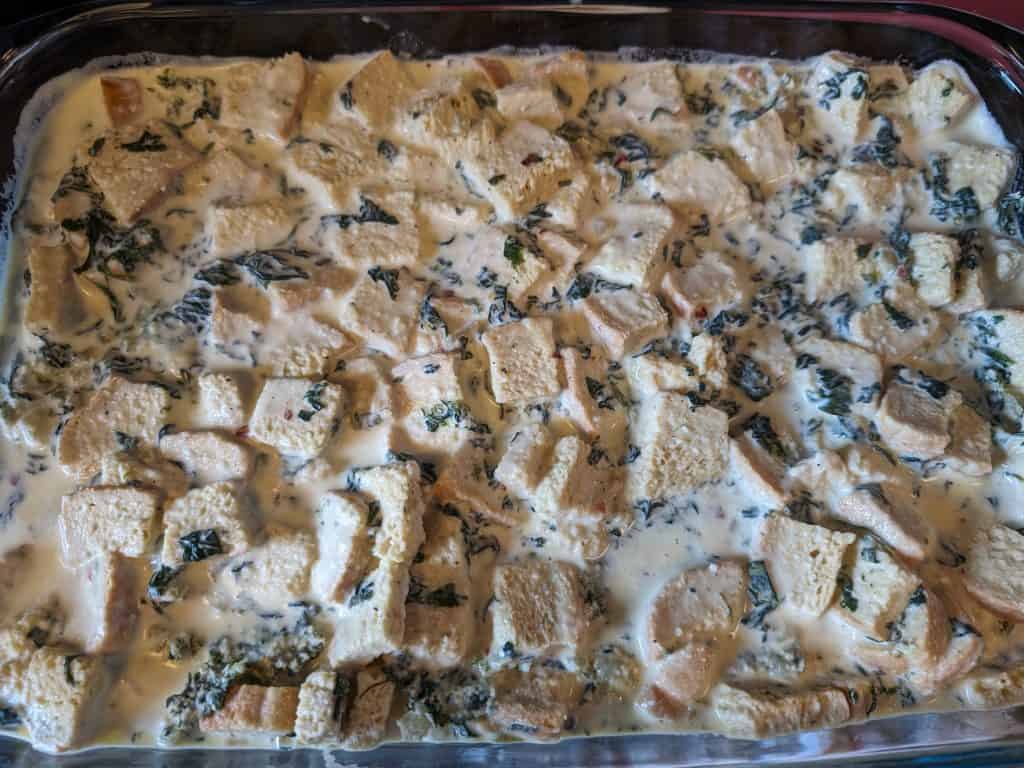 Third layer in pan of egg, cream, bread, and spinach mixture for Keto Florentine Breakfast Strata