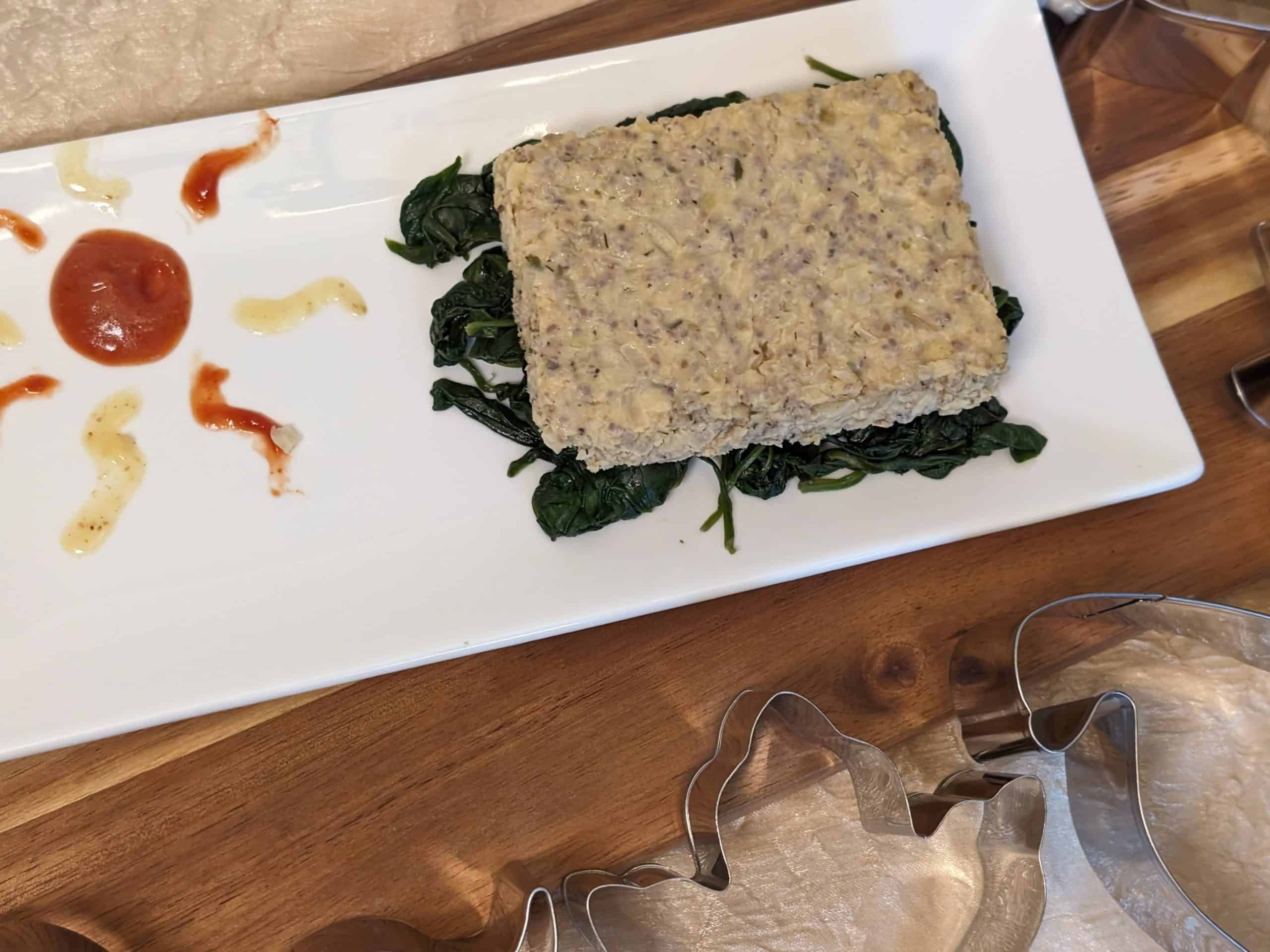 Ranch Cauliflower Chia Cakes plated on a bed of sautéed spinach