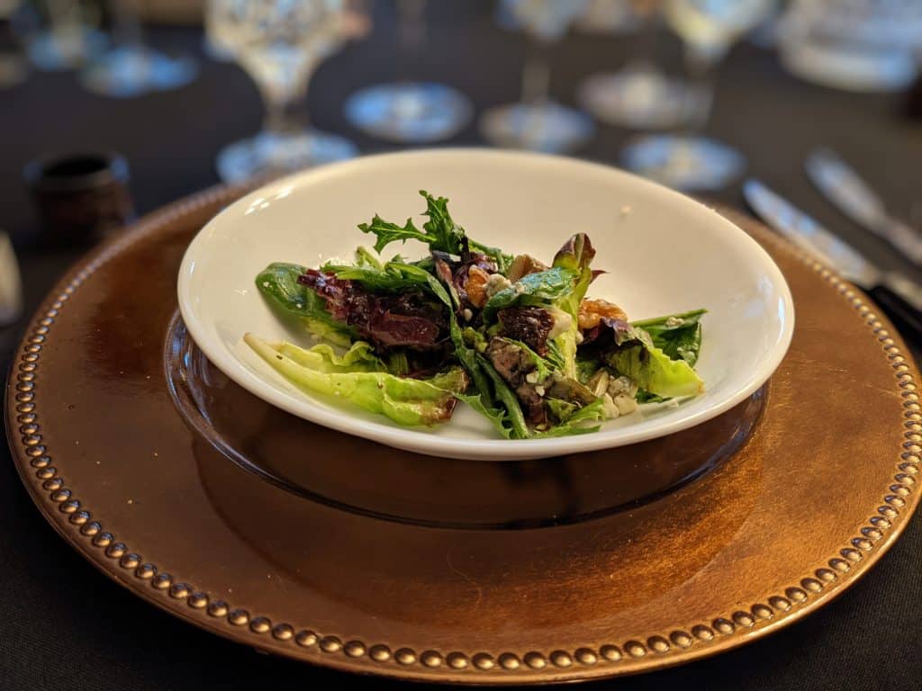 Spring Salad in a white bowl on a copper charger