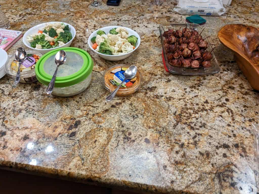 Buffet set up with 3 dips, vegetable dippers, and Bacon-Wrapped Low Carb BBQ Hot Dog Bites