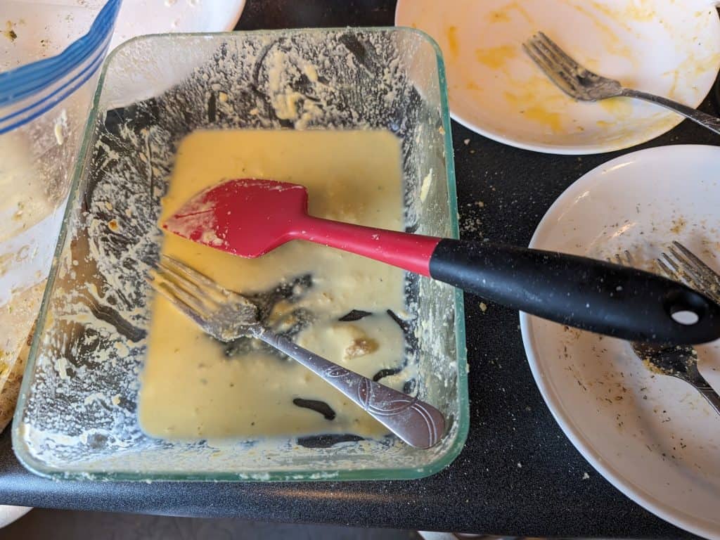 Deep glass dish with egg and heavy cream mixture for dipping the dinosaur chicken patties