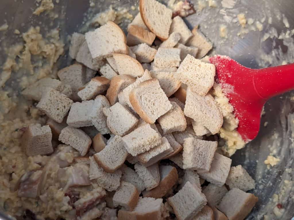 Folding keto bread cubes into the mixture for Keto Kentucky Hot Brown Casserole