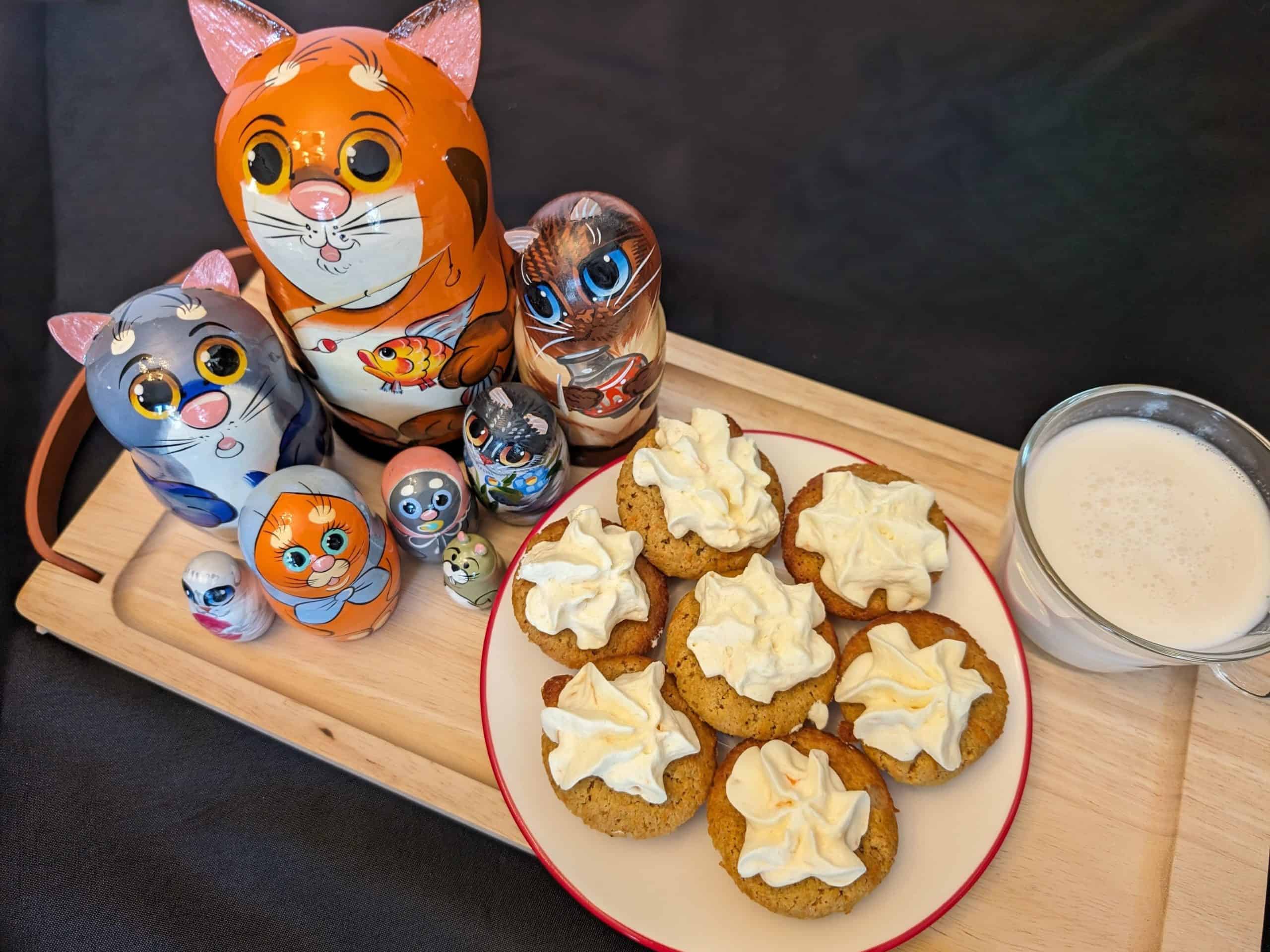 Feature Image for Small Bites and Creamy Cheesy Delights Dinner Party showing cat matryoshka dolls, a small cup of milk, and small cookie bites with a cream cheese frosting
